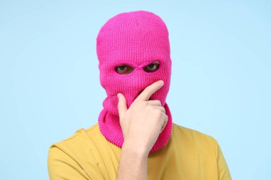 Mavi arka planda kar maskeli yakışıklı bir genç.