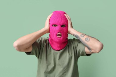 Yeşil arka planda kar maskeli yakışıklı genç adam.