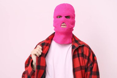 Pembe arka planda kar maskeli yakışıklı bir genç.