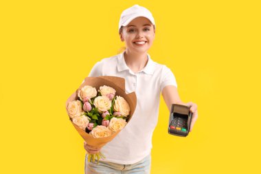 Sarı arka planda çiçek buketi ve ödeme terminali olan kadın kurye.