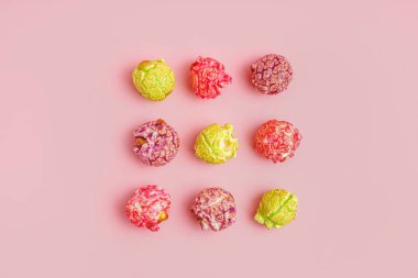 Pembe arka planda tatlı renkli patlamış mısır