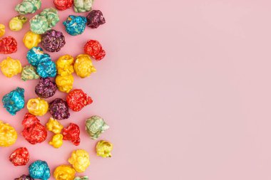 Pembe arka planda tatlı renkli patlamış mısır