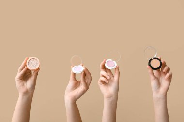 Göz farı olan kadın eller, bej arka planda fosforlu kalem ve toz.