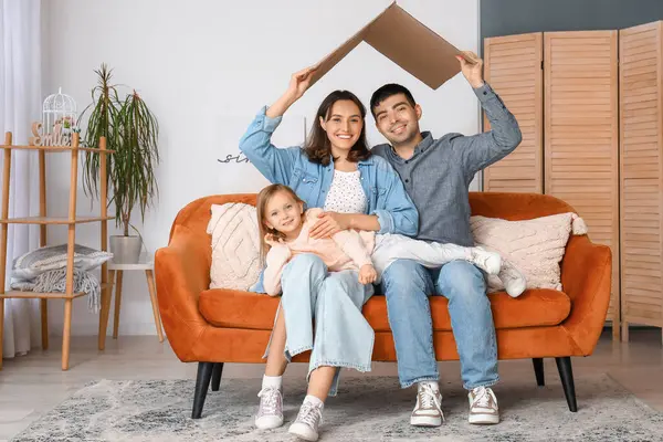 Kartonla mutlu bir aile oturma odasındaki yeni evlerini düşlüyor.