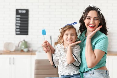 Güzel bir manken kadın ve kızı mutfakta mutfak aletleriyle...