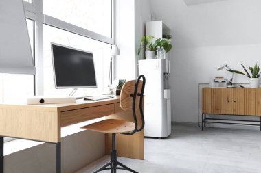 Bilgisayarlı, projektörlü, çekmeceli, masa ve sandalyeli ışık ofisinin içi