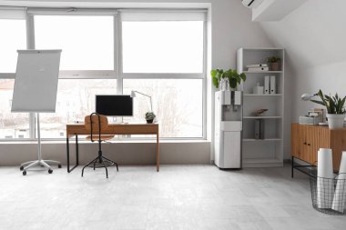 İçinde bilgisayar, tahta, çekmece, masa ve sandalye olan hafif ofis.