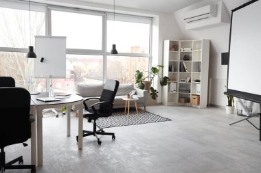 Masası, koltuğu ve koltukları olan şık bir konferans salonu.