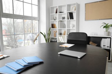 Ofisinde dosya ve dizüstü bilgisayarı olan masa toplantı için hazır.