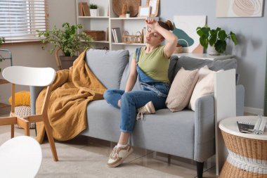 Evde mobilya toplamaktan yorgun düşmüş genç bir kadın.