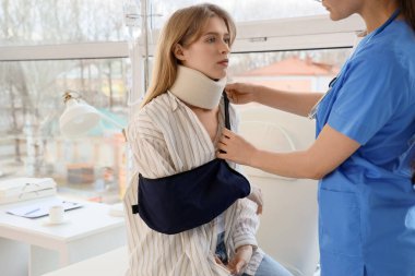 Klinikteki doktoru ziyaret ettikten sonra kolu kırılan yaralı genç bir kadın.