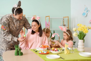 Ailesiyle birlikte erkek asker ve akşam yemeğinde paskalya yumurtası.
