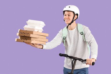 Pizza kutuları ve yiyecek konteynırları olan erkek kurye leylak arka planda scooter kullanıyor.