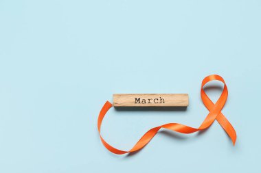 Kelime Marşı ve turuncu kurdele mavi arka planda. Çoklu Skleroz Farkındalık Ayı