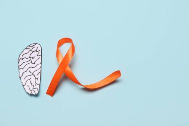 Kağıt beyin ve mavi arka planda turuncu kurdele. Çoklu Skleroz Farkındalık Ayı