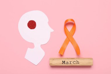 Kağıt beyin, Kelime Marşı ve pembe arka planda turuncu kurdele. Çoklu Skleroz Farkındalık Ayı