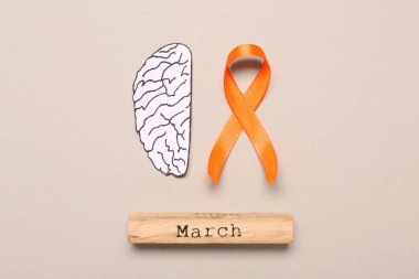 Turuncu kurdele, kağıt beyin ve gri arka planda marş. Çoklu Skleroz Farkındalık Ayı