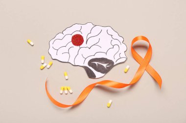 Turuncu kurdele, kağıt beyin ve gri arka planda haplar. Çoklu Skleroz Farkındalık Ayı