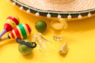 Sarı arka planda tekila, limon ve marakas.