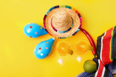 Sarı arka planda tekila, limon ve marakas.