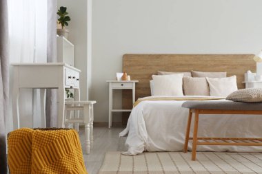 Yatak odası, masa yastıkları ve komodinli.