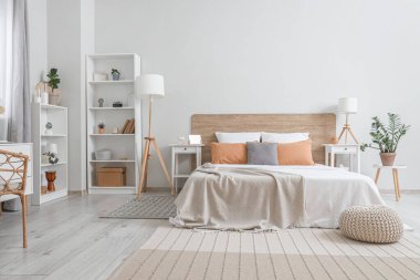 Büyük yataklı, raf üniteli, lamba ve komodinli modern yatak odası.