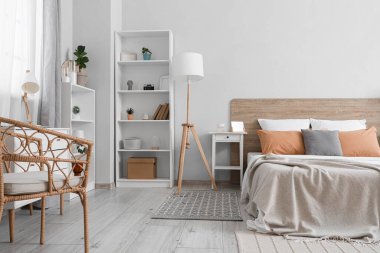 Büyük yataklı, raf üniteli, lamba ve komodinli modern yatak odası.