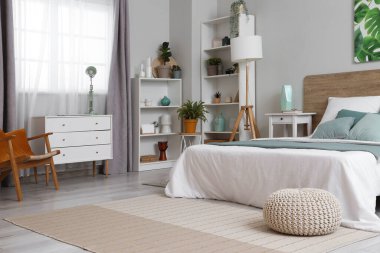 Yatak odasının içi yumuşak yatak, lambalar, raf üniteleri ve komodinlerle dolu.