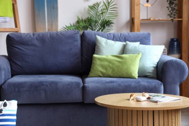 Mavi kanepesi ve sörf tahtası olan şık bir oturma odası.