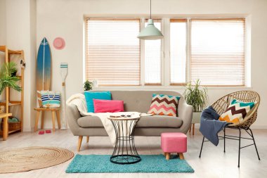 Raflar, sörf tahtası ve gri kanepeli şık bir oturma odası.