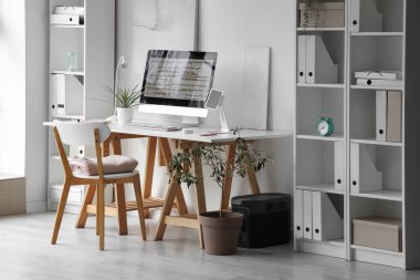 Programcı işyeri ve raf üniteleriyle şık bir ofis.