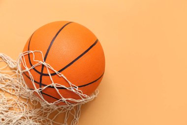 Turuncu zemin üzerinde ağ olan basketbol