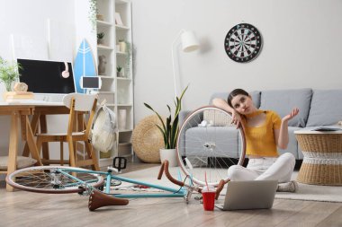 Evde bisiklet tamir eden üzgün bir bayan öğrenci.