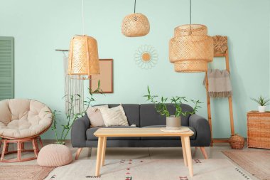 Rahat siyah kanepesi ve bambu bitkisi olan modern oturma odası.