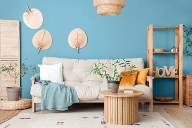 Kahve masası ve kanepenin üzerinde bambu sapları olan şık bir oturma odası.