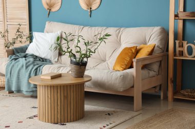 Kahve masası ve kanepenin üzerinde bambu sapları olan şık bir oturma odası.