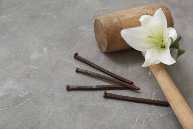 Hammer, lily and nails on grey background clipart