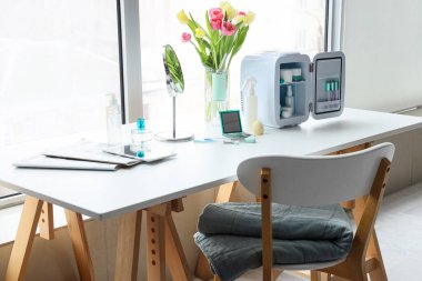 Pencerenin yanındaki masada küçük kozmetik buzdolabı