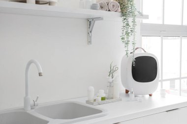 Kozmetik ürünleri olan küçük bir buzdolabı ve banyodaki çekmecelerin üzerine lavabo.