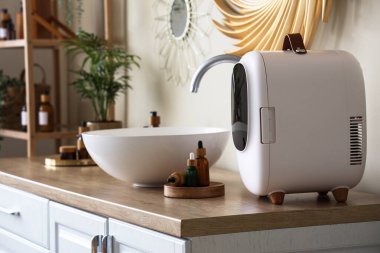 İçinde ürünler olan kozmetik buzdolabı ve banyo çekmecesinde lavabo.