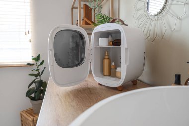 Kozmetik buzdolabı. Banyoda duvarın yanındaki çekmecelerin üzerinde ürünler var.