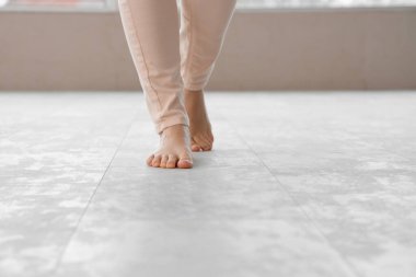 Genç bir kadın yeni lamine döşeme üzerinde yürüyor.