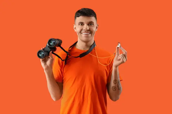 stock image Male lifeguard with binoculars and whistle on orange background