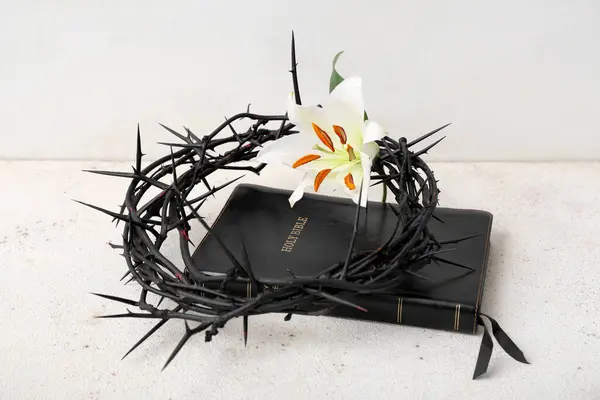 stock image Holy Bible and crown of thorns with lily on grunge table near white wall