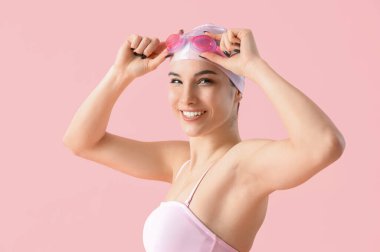 Pembe arka planda kadın yüzücü, yakın plan.