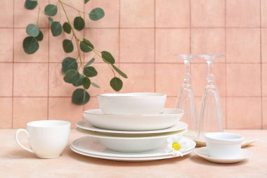 Turuncu kiremit duvarın yanındaki masada güzel sofra takımı ve yapraklar