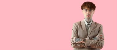 Pembe arka planda genç dövmeli işadamı, mesaj için yeri var.