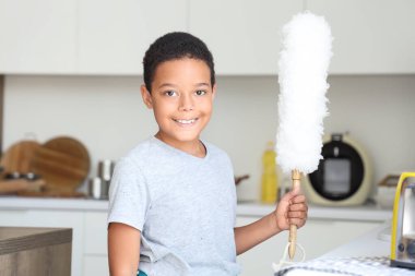 Mutfakta toz bezi olan tatlı Afro-Amerikan çocuk.