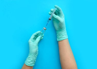 Mavi arka planda tıbbi şırıngası olan kadın doktor.
