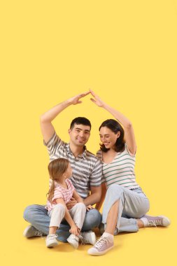 Mutlu aile sarı arka planda yeni evlerini düşlüyor.